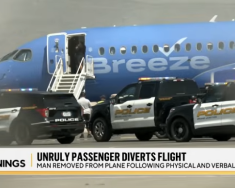 Unruly airline passenger being removed from plane